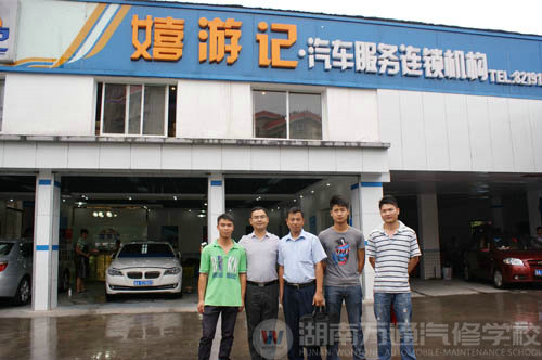 嘻游記汽車服務(wù)連鎖機(jī)構(gòu)門口,陸金勇等幾位畢業(yè)學(xué)子與公司老總和陸主管合影